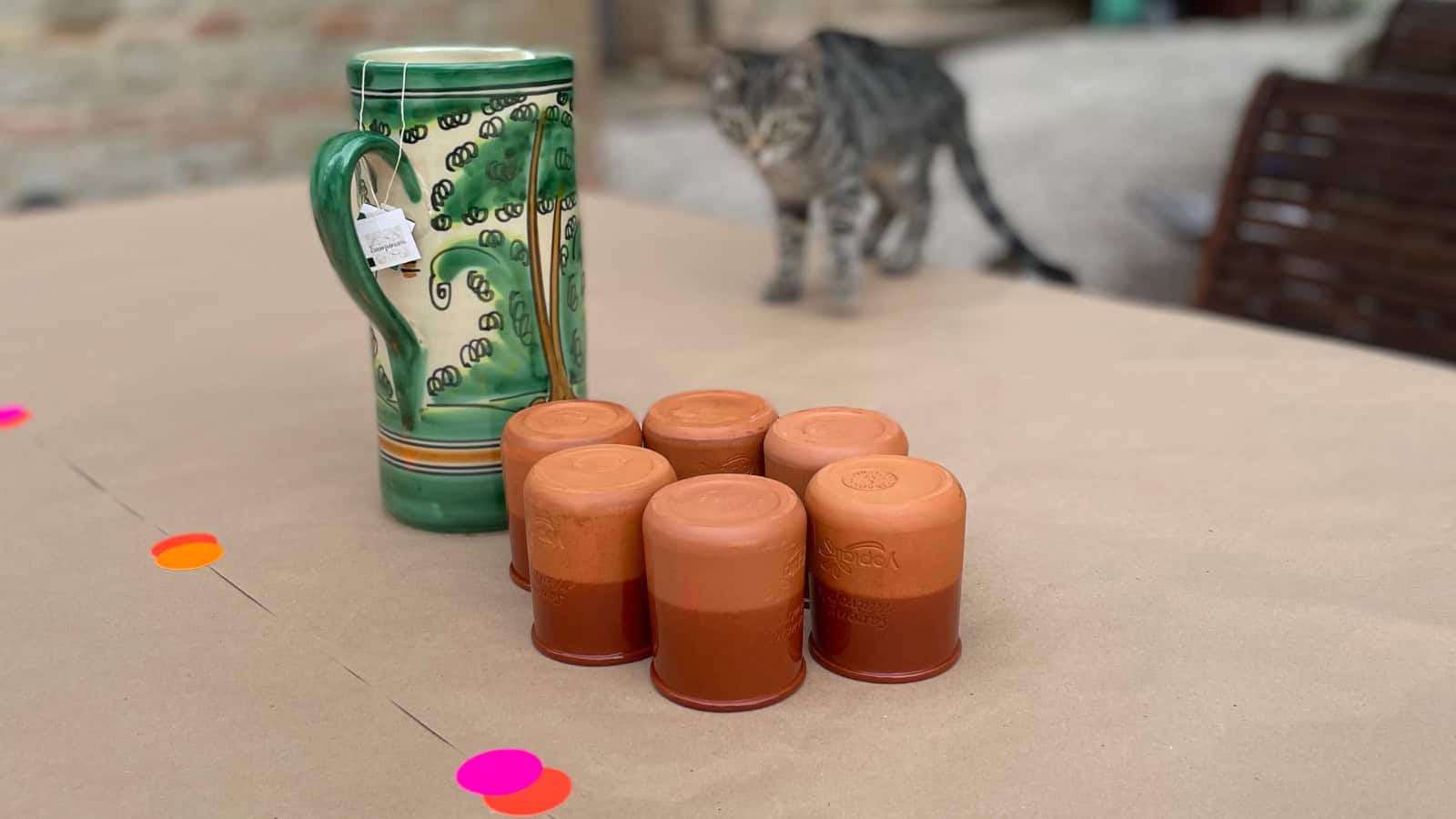 Becher auf einem Tisch mit Katze im Hintergrund