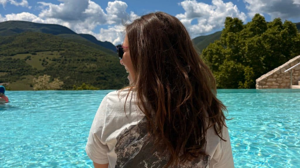 frau von hinten vor Swimmingpool in den Bergen